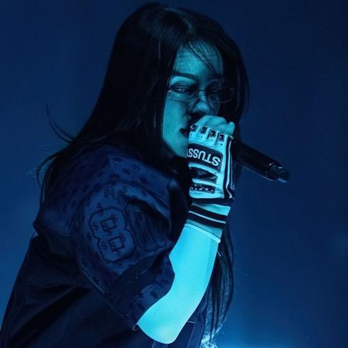 Billie Eilish in blue stage lighting
